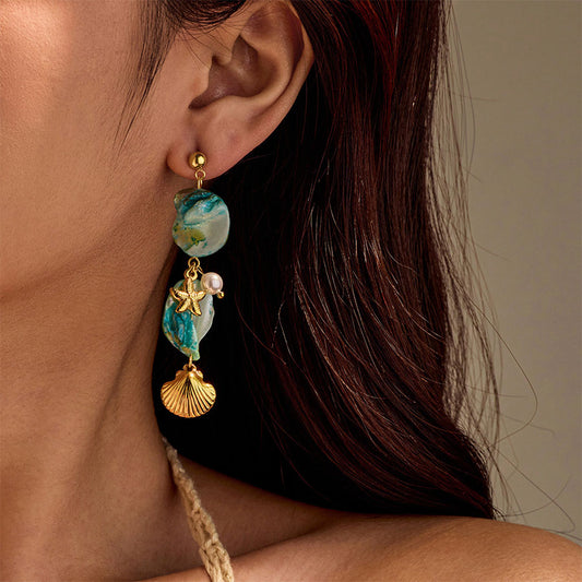 Close-up of an ear wearing a decorative earring with beads and charms.