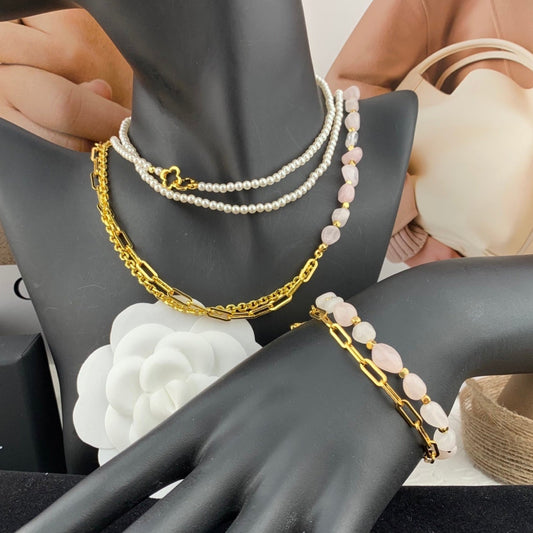 Mannequin hand wearing gold and pearl bracelets with a blurred background