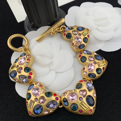 Gold bracelet with multicolored gemstones on a white flower background
