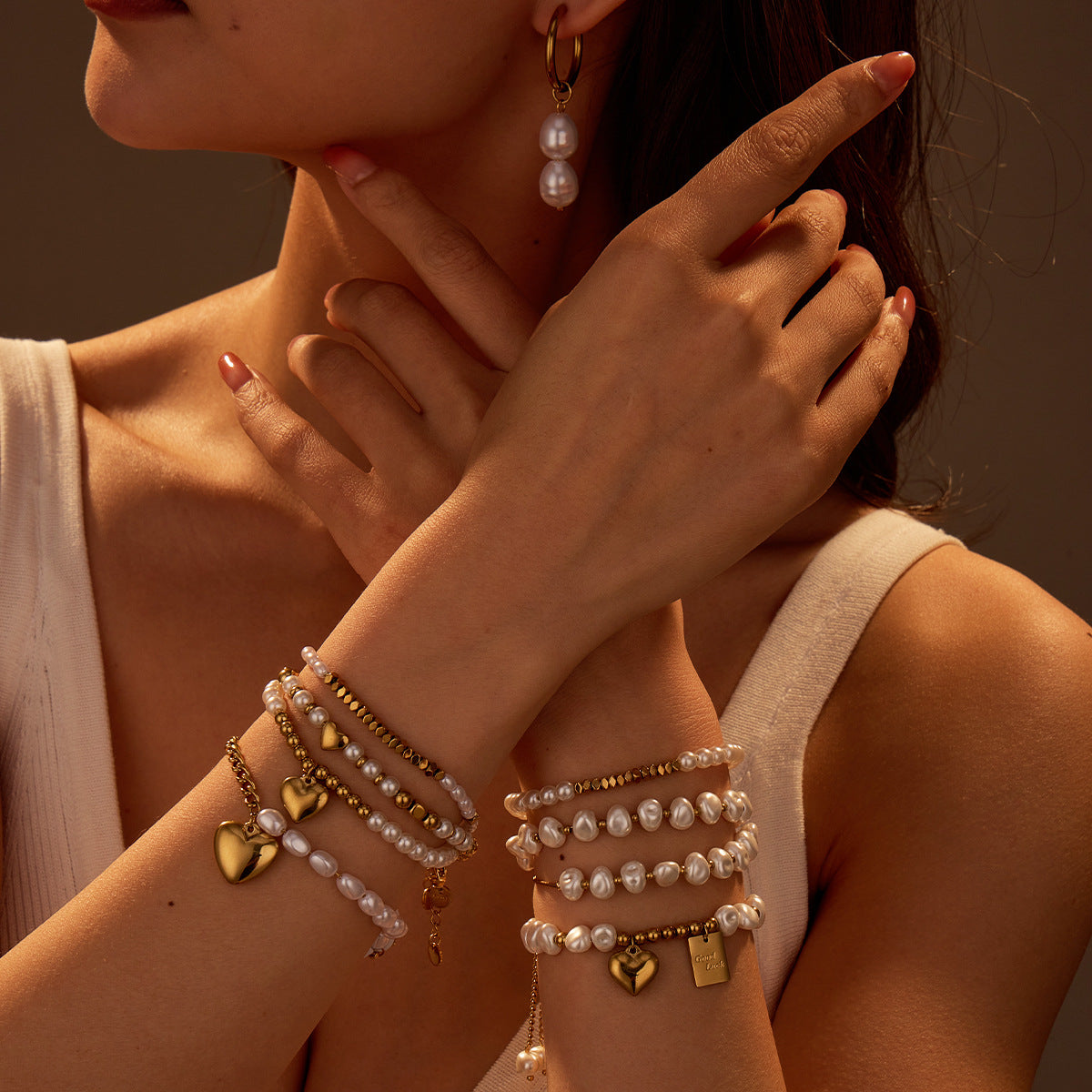 Close-up of a person wearing multiple bracelets and an earring with a warm, brownish hue.