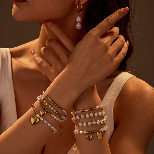 Close-up of a person wearing multiple bracelets and an earring with a warm, brownish hue.