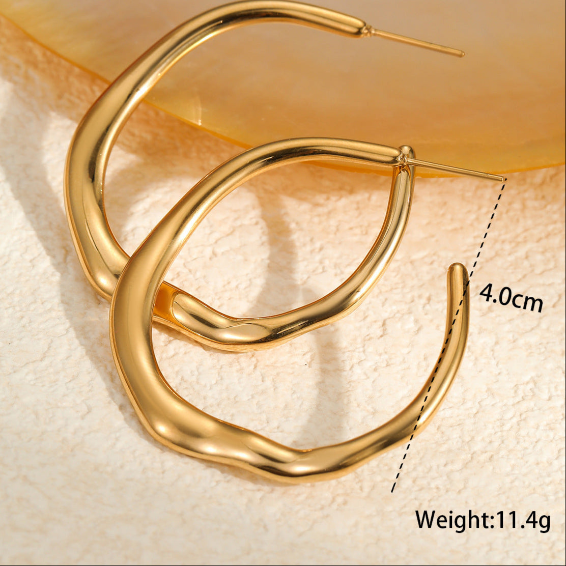 Gold hoop earrings on a textured beige surface with measurement details.