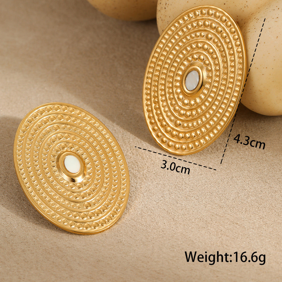 Gold circular earrings with intricate designs on a beige background, showing measurements and weight.