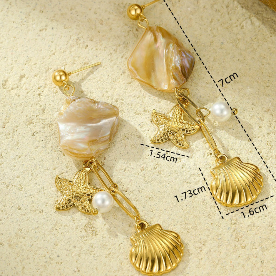 Gold earrings with shell and starfish charms on a beige background with measurements.
