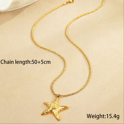 Gold chain necklace with a star pendant on a beige background