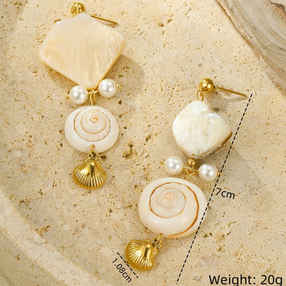 Shell and pearl earrings on a textured beige surface with measurements and weight displayed.