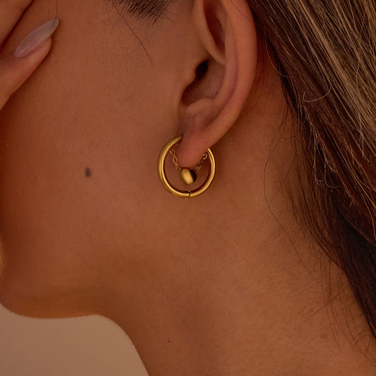 Close-up of a gold hoop earring worn by a person.
