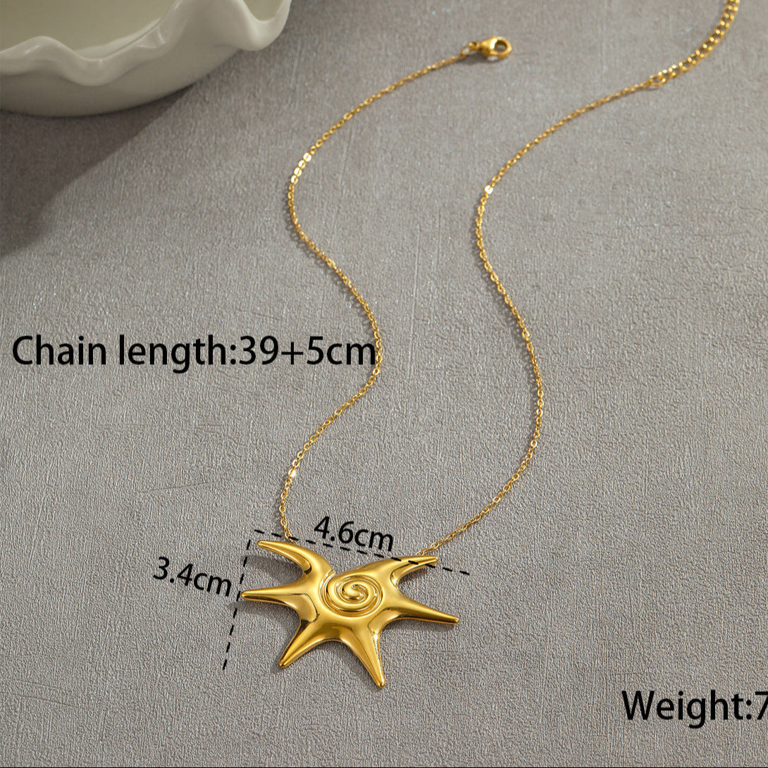 Gold necklace with a star-shaped pendant on a gray surface, showing measurements and weight.
