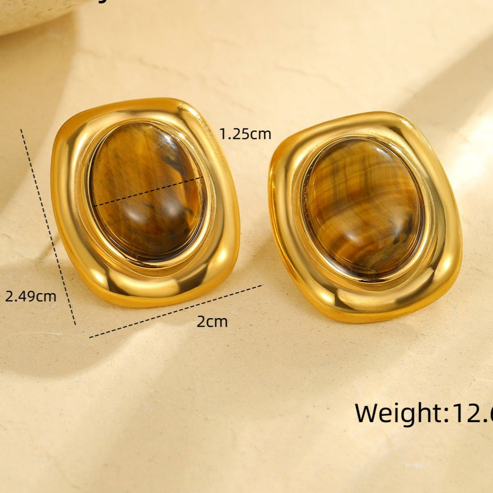 Gold earrings with gemstones on a beige background, showing measurements and weight.