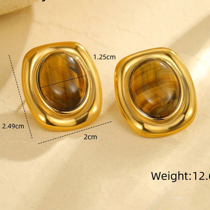 Gold earrings with gemstones on a beige background, showing measurements and weight.