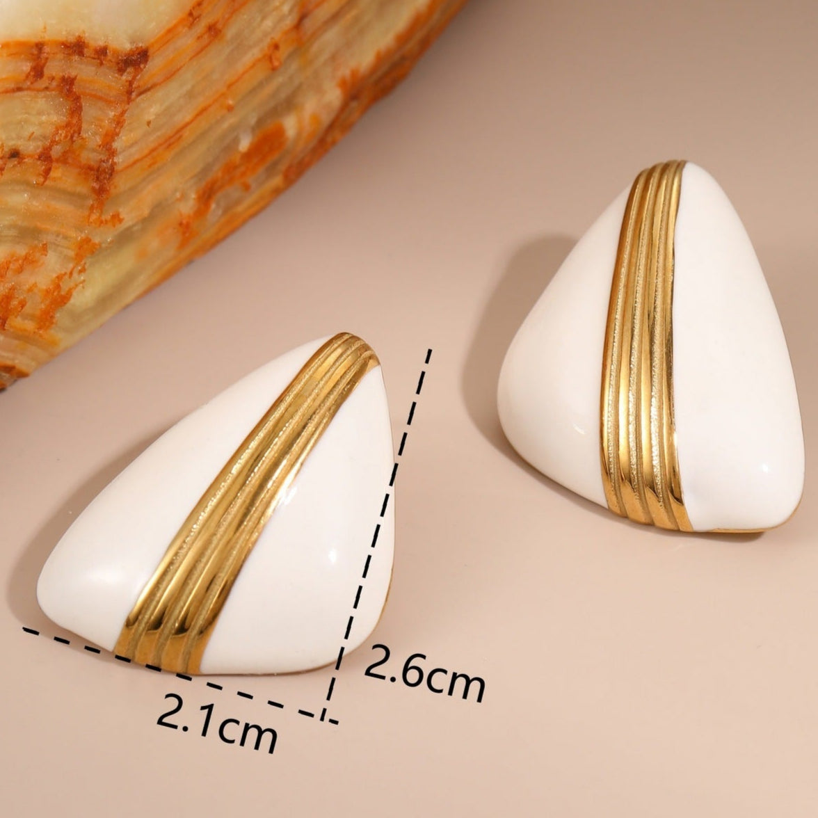 White earrings with gold stripes on a beige background, showing measurements and weight.