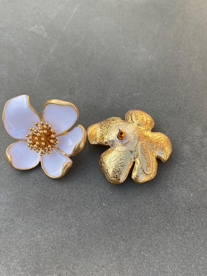 Two floral earrings on a gray background