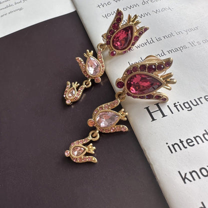 Gold and red gemstone earrings on a book page