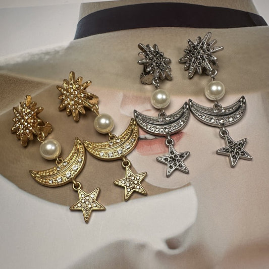 Set of star and moon-shaped earrings on a mannequin head.