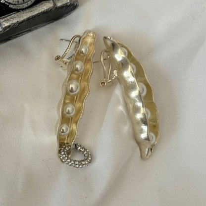 Gold earrings with pearl-like beads on a white background