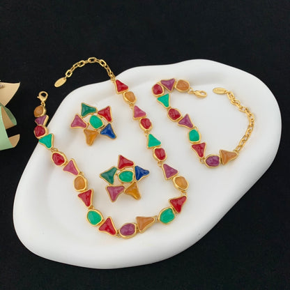 Colorful geometric necklace and bracelet set on a white stone surface with a black background