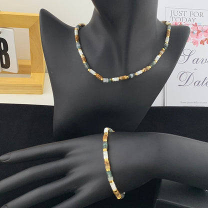 Necklace and bracelet set on a mannequin with a decorative background