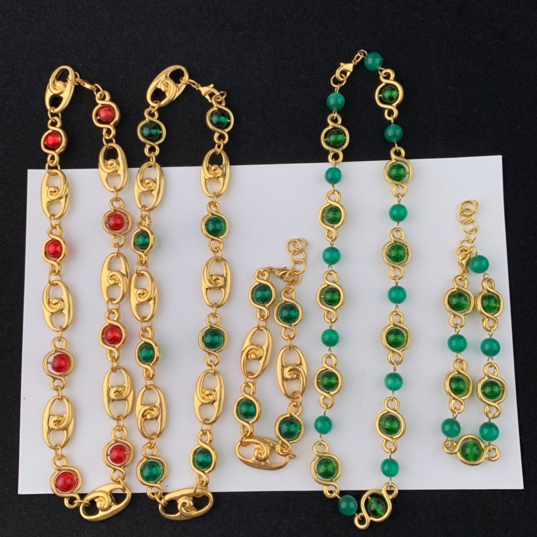 Gold and gemstone jewelry set on a white card with a black background