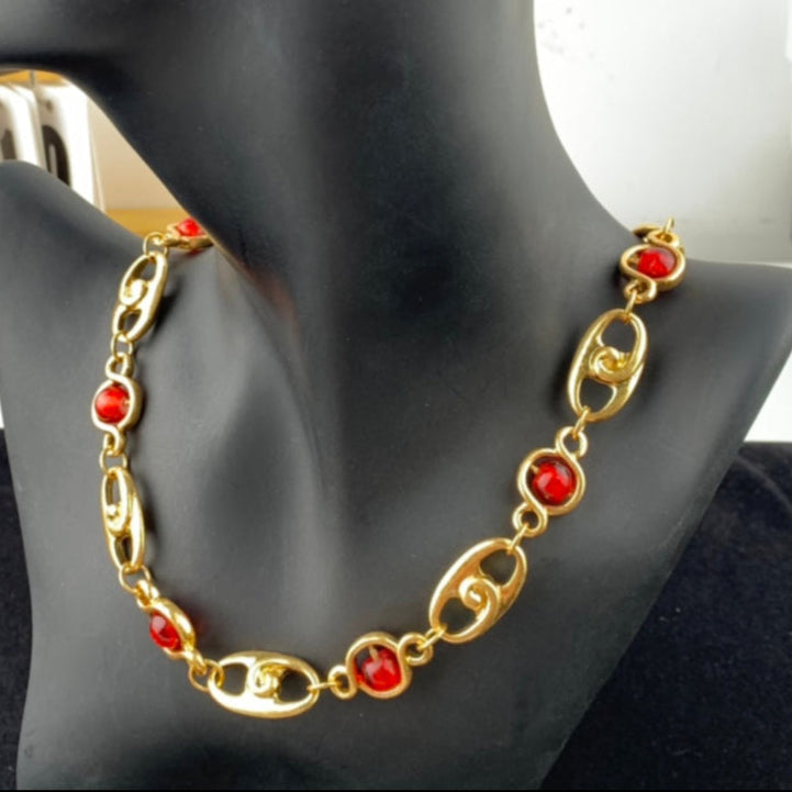 Gold necklace with red stones on a black mannequin bust