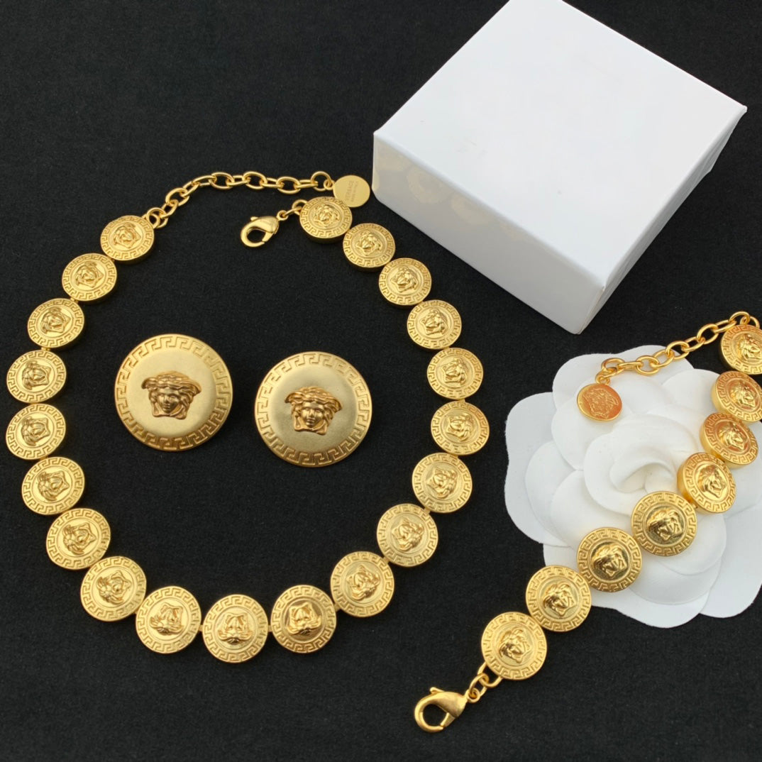 Gold necklace with coin-like design on a black background
